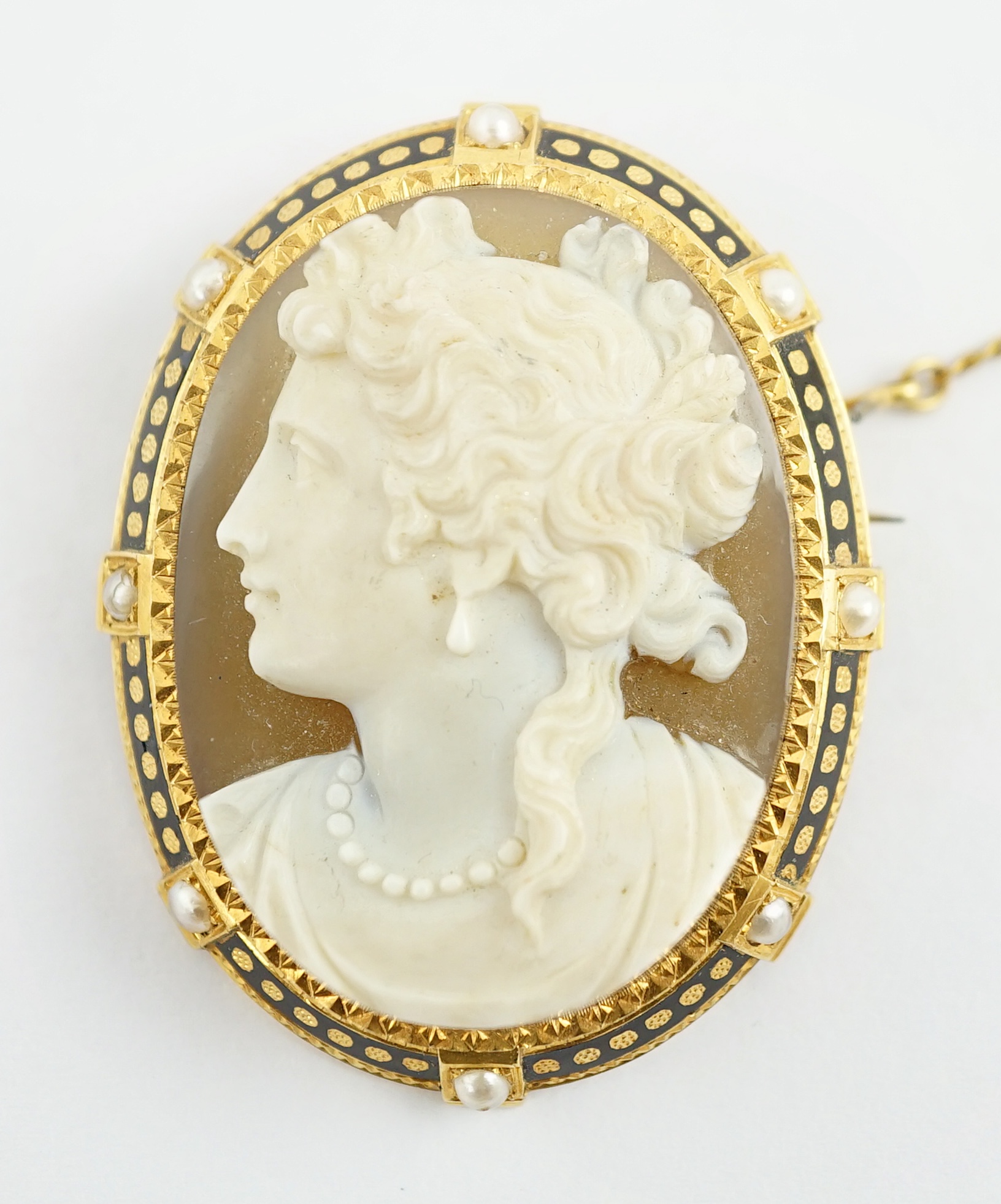 A Victorian gold, enamel and seed pearl mounted oval cameo hardstone brooch